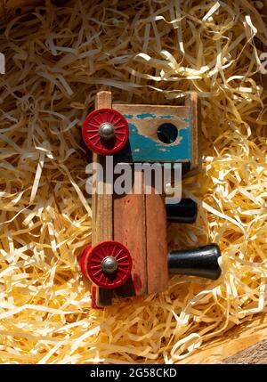 Vertical closeup shot of a wooden toy train on shredded yellow paper Stock Photo