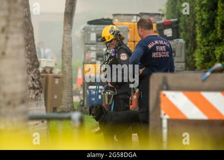 Surfside, Florida, USA. 25th June, 2021. USA: Firefighters and search dog take a break from rescue mission by the collapsed condo in Surfside where 4 were killed and over 100 missing. Credit: Orit Ben-Ezzer/ZUMA Wire/Alamy Live News Stock Photo