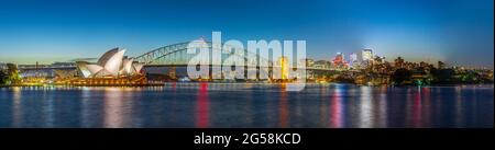 Panorama night view of Sydney Harbour and City Skyline of NSW Australia bright neon lights reflecting off the water Stock Photo