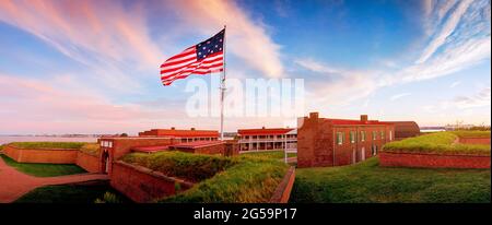 Flag waves over Fort McHenry in Baltimore MD. Fort McHenry above the Patapsco River on 4th July, USA Stock Photo