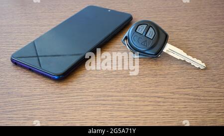 Smartphone and car keys on the table Stock Photo