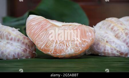 Close-up of peeled grapefruit on a banana leaf Stock Photo