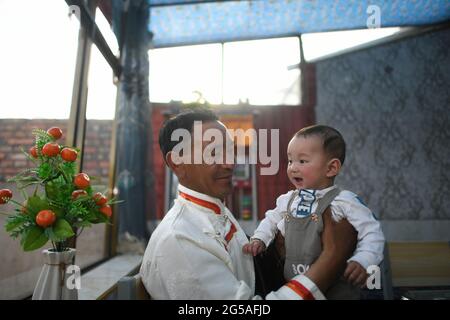 Beijing, China's Qinghai Province. 8th June, 2021. Herdsman Sonam Tsering poses for a photo with his grandson at a mountainous rural village in Gangcha County of Haibei Tibetan Autonomous Prefecture, northwest China's Qinghai Province, June 8, 2021. Credit: Wu Gang/Xinhua/Alamy Live News Stock Photo