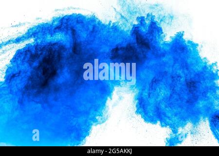 Bizarre forms of blue powder explosion cloud on white background.Launched blue dust particles splashing. Stock Photo