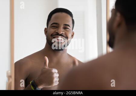 Happy attractive young African man looking and smiling at camera Stock Photo
