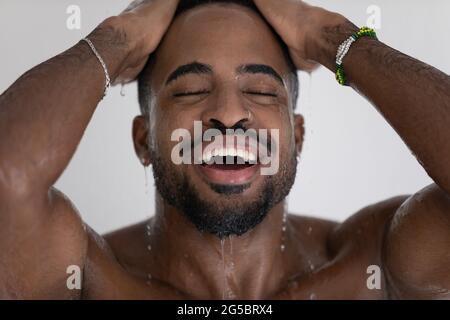Handsome mixed race black man relaxing and taking shower Stock Photo