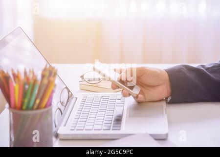 A young businessman using smartphone connecting to customer, Looking for direction and inspiration. Stock Photo