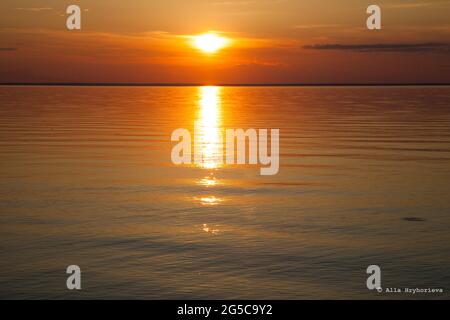 Calm on the coast. The sky in the evening. Water. Sunset sky on the coast. Golden hour. Sky and clouds. Feather cloud. The sun went down below the horizon. Evening sky background. Sunrise landscape. Stock Photo