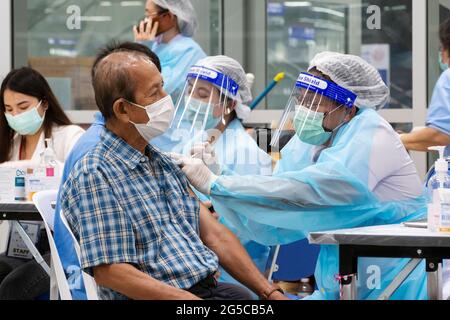 Bangkok, Thailand - June 29, 2021 : asian doctor or nurse giving covid antivirus vaccine shot to senior man patient wearing protective face mask from Stock Photo