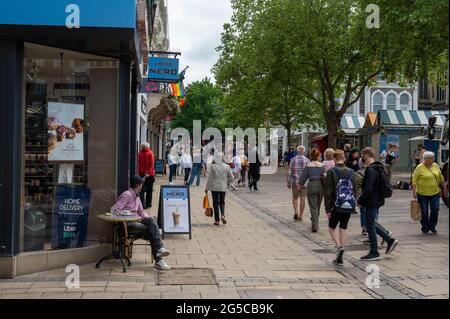 A busy city centre street with lots of shoppers walking around on a sunny summers day Stock Photo