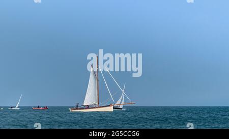 Traditional gaff rigged sailing boat (yacht) sails during sail club regatta near Greystones, Irish sea. Stock Photo