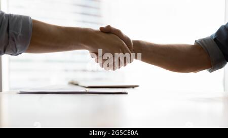 Close up two male business men shaking hands, making agreement. Stock Photo