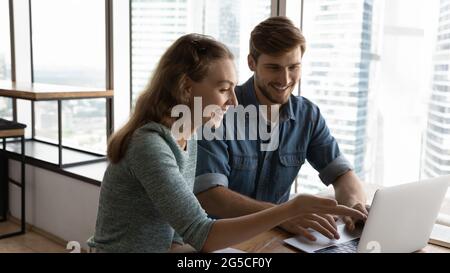 Happy two colleagues working on online project. Stock Photo