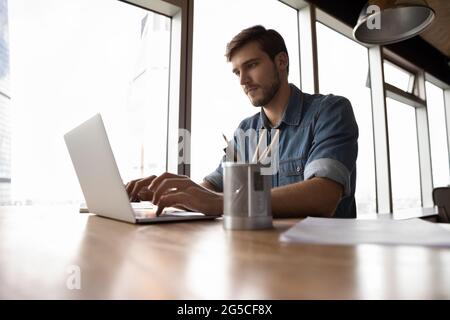 Focused young male manager working on computer. Stock Photo