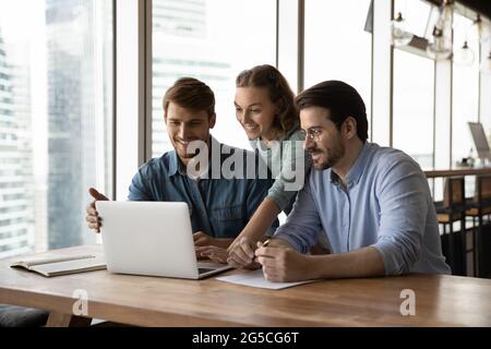 Happy three teammates working together on online project. Stock Photo