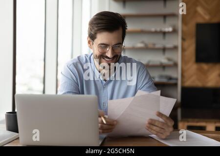 Happy young successful businessman analyzing paper documents. Stock Photo