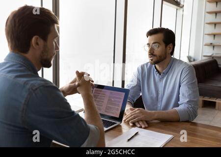 Skilled young male hr manager holding job interview with candidate. Stock Photo