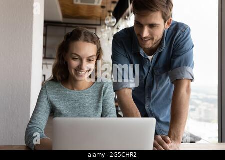 Happy two teammates employees working together on online project. Stock Photo