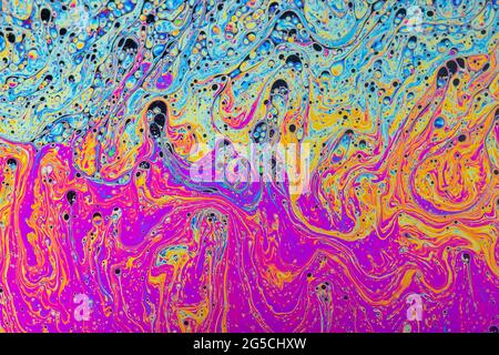 Fluid soap bubble psychedelic colorful abstract art. Surreal patterns with rainbows and waves of color in motion. Stock Photo