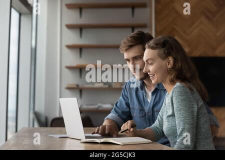 Joyful young family couple using computer apps. Stock Photo