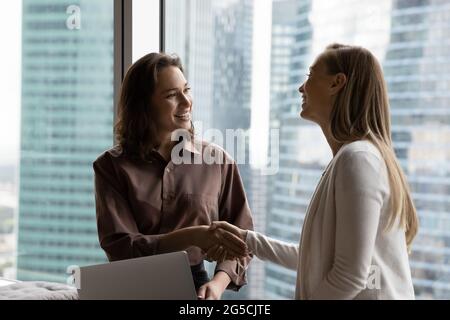 Smiling two business women shaking hands making agreement. Stock Photo