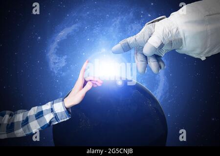 close up the hand of human and the astronaut touch in the outer space, elements of this image furnished by nasa Stock Photo