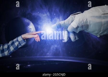 close up the hand of human and the astronaut touch in the outer space, elements of this image furnished by nasa Stock Photo