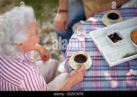 detail of elderly couple having breakfast and drinking coffee outdoor. top view. Stock Photo