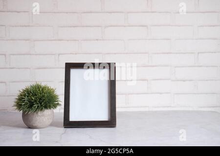 empty frame on table against white wall  Stock Photo
