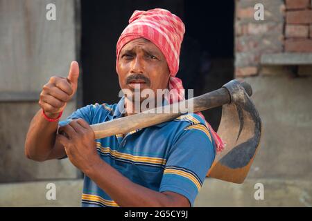 Portrait of a Farmer holding a Shovel showing thumbs up sign Stock ...