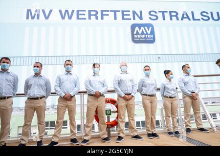 Stralsund, Germany. 26th June, 2021. Crew members stand on deck for the christening of the new expedition cruise ship 'Crystal Endeavor'. The 'Crystal Endeavor' is the first new ship to be built following the takeover of the Stralsund shipyard by the Asian parent company Genting Hong Kong. Credit: Stefan Sauer/dpa/Alamy Live News Stock Photo