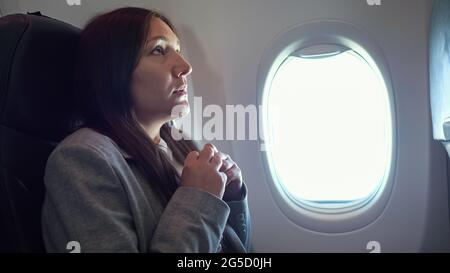 Young woman is very afraid of flying on an airplane. Stock Photo
