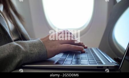 close-up of female hands typing on a laptop against the background of a porthole, . Stock Photo