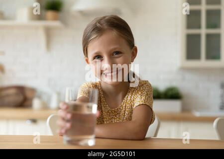 Smiling cute little child girl proposing aqua to camera. Stock Photo