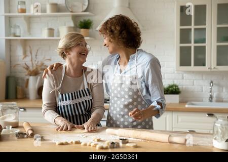 Smiling female family enjoying cooking together at home. Stock Photo
