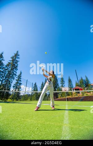 Slim gorgeous girl ready to play in tennis on court in bright summer day. Stock Photo