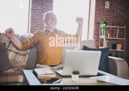 Portrait of handsome man sit on sofa closed eyes toothy smile stretch arms rest relax working from home indoors Stock Photo