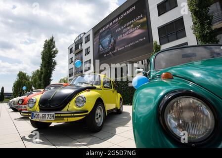 Wolfsburg, Germany. 26th June, 2021. VW Beetles of different years and  types are parked on Piazza in the Autostadt. Fans of the old VW Beetle meet  with their cars in the Autostadt