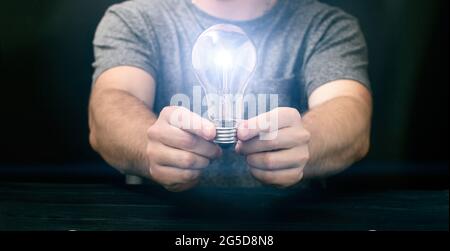 Creative new idea. Innovation, brainstorming, inspiration and solution concepts. Man holding light bulb, Stock Photo