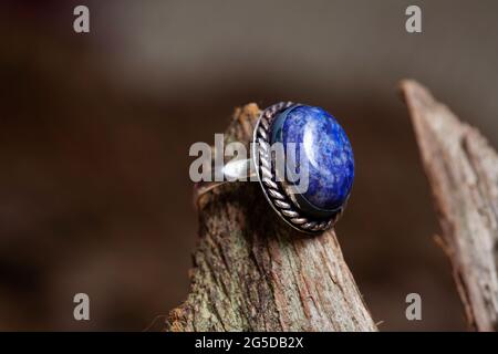 Brass metal lapis lazuli mineral stone ring on natural background Stock Photo