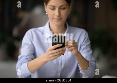 Young business woman using smartphone application in office. Stock Photo