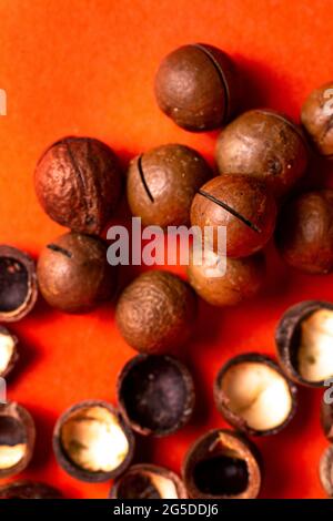 macadamia nuts and shells on a red background top view. Stock Photo