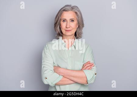 Photo of happy smiling positive confident businesswoman with folded hands isolated on grey color background Stock Photo