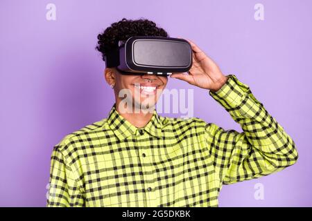 Portrait of handsome cheerful guy wear vr device screen having fun isolated on violet purple color background Stock Photo