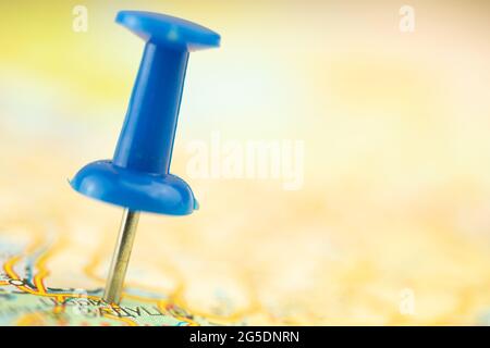 Close-up to the blue pushpin on the tourist map, selective focus Stock Photo