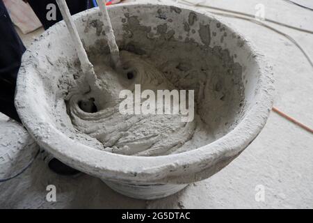 the builder mixes the construction mixture in a container for guiding ...