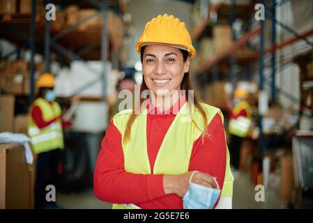 Smiling female warehouse worker looking at camera Stock Photo