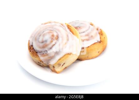 Two Frosted Cinnamon Rolls on a White Plate Stock Photo