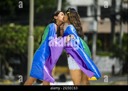 San Salvador, El Salvador. 26th June, 2021. Participants seen under a huge rainbow flag, during the Pride March.Members of the LGBT community took to the streets to perform in an annual Pride Parade celebrating diversity and protest for human rights laws to be approved by Congress. (Photo by Camilo Freedman/SOPA Images/Sipa USA) Credit: Sipa USA/Alamy Live News Stock Photo