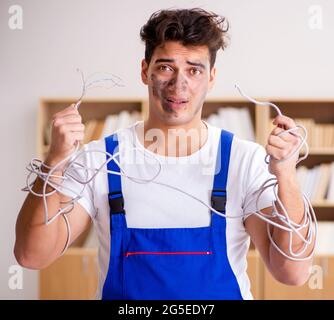 The funny man doing electrical repairs at home Stock Photo